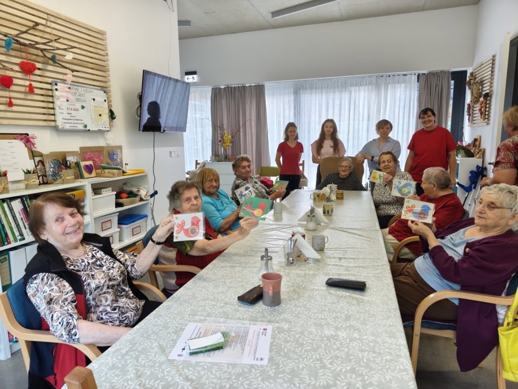 Senioři s dobrovolnicemi při společném tvoření v domově